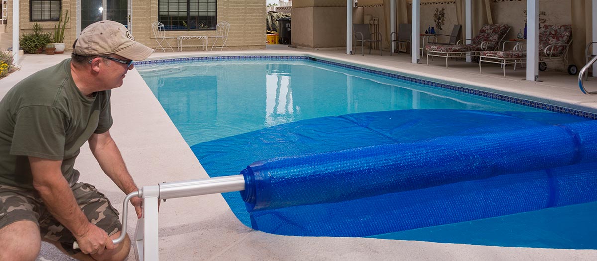 Man covering pool with tarp