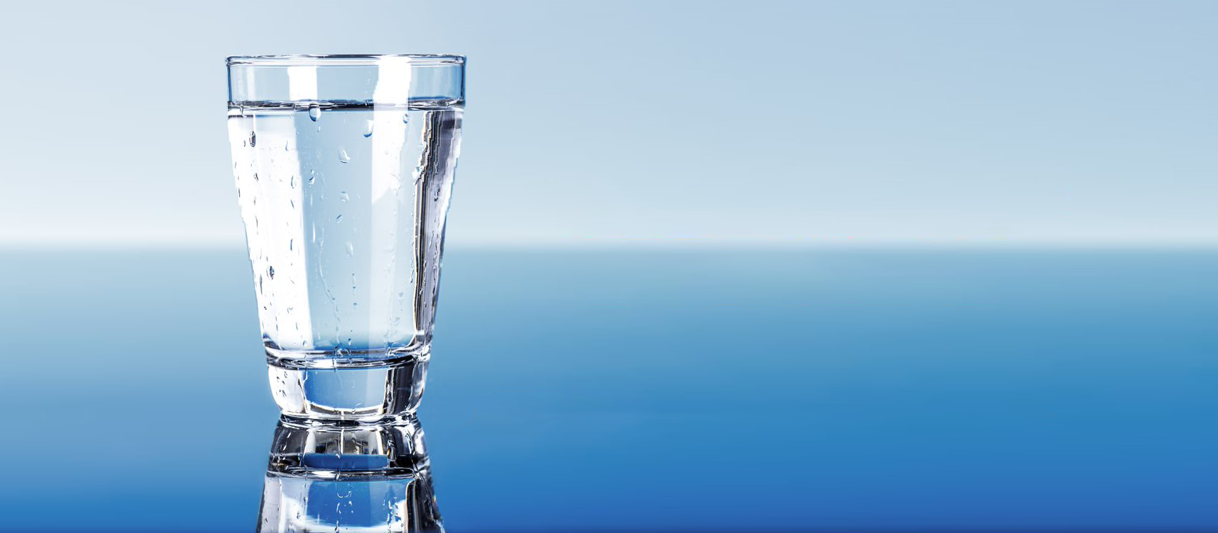 Un vaso de agua clara sobre un fondo azul degradado.