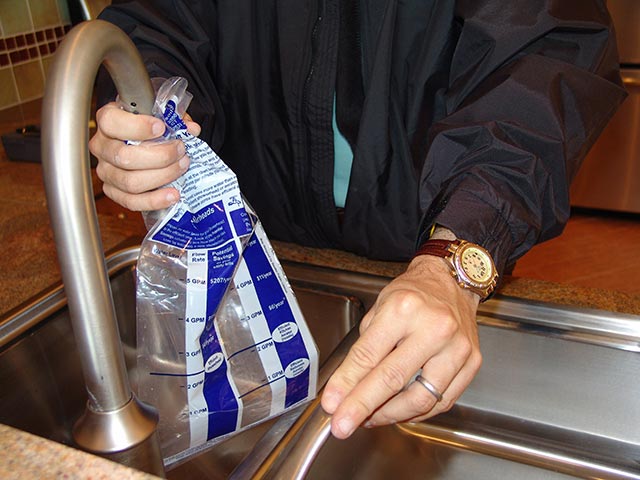 Man filling bag of water audit kit