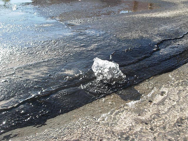 Water bubbling up from asphalt